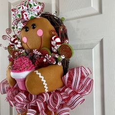 a door hanger with a gingerbread man holding a cupcake and candy canes