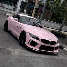 a pink car is parked on the street