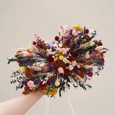 a bouquet of flowers is being held by someone's hand