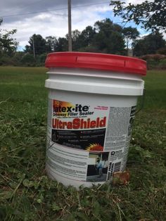 a bucket sitting in the middle of some grass