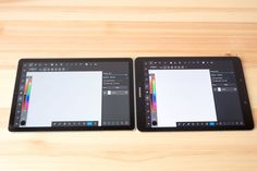 two tablet computers sitting on top of a wooden table