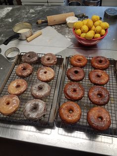 doughnuts and lemons are sitting on cooling racks in front of the counter