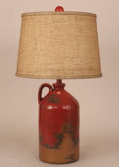 a red vase with a brown base and a beige shade on the top is sitting in front of a white background