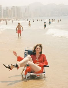 a woman sitting in a chair on the beach