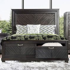 a bed with drawers underneath it and pillows on the headboard, in front of a window