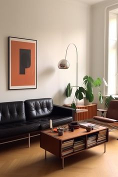 a living room with black leather couches and a coffee table in front of a window