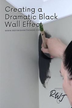 a woman is painting the wall black with a paint roller in her hand and text overlay that reads, creating a dramatic black wall effect