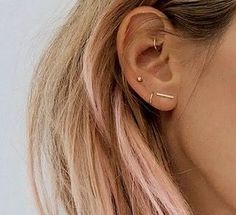 a close up of a person with ear piercings on their ears and wearing earrings