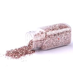 a jar filled with pink glitter on top of a white table