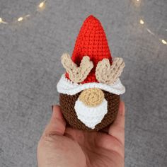 a hand holding a small crocheted christmas decoration