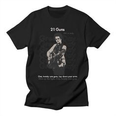 a black t - shirt with an image of a man holding a guitar on it