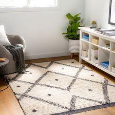 a living room with a chair, rug and bookshelf