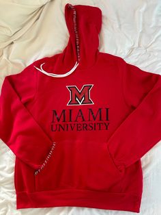 Introducing our college custom hand-embroidered sweatshirt! Hand-stitched to perfection, this stylish sweatshirt is the perfect addition to any wardrobe. A red Bella&Canvas hoodie with black and white hand-stitched details  Represent your university or college or your  favorite sport team. Makes a great gift for a high-school graduate or parents of incoming freshmen.  Crafted with care and attention to detail, this custom embroidered sweatshirt is made to last. With high-quality materials and expert craftsmanship, it's sure to become a favorite piece in your wardrobe for years to come. So why wait? Add some personality to your wardrobe and order your custom embroidered sweatshirt today! Details: This is a unisex Bella&Canvas sweatshirt and fits true to size (see size chart in photos). Plea Custom Embroidered Sweatshirt, Miami University, University Hoodie, College Sweatshirt, University Of Miami, White Hand, Embroidered Sweatshirt, Cozy Fits, Embroidered Sweatshirts