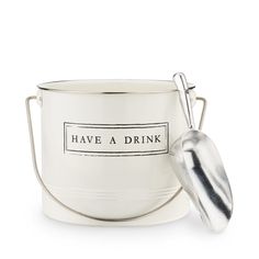 a white bucket with a metal spoon in front of it that says have a drink