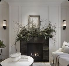 a living room filled with furniture and a fire place in front of a white fireplace