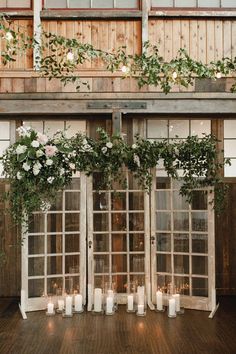 an outdoor ceremony with candles and greenery on the windows, decorated with flowers and foliage