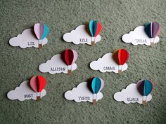 several hot air balloons with name tags attached to them sitting on the floor next to each other