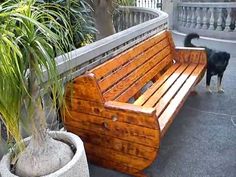 a wooden bench sitting next to a potted plant