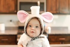 a baby wearing a bunny costume in a kitchen