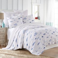 a bed with white and blue comforters in a bedroom