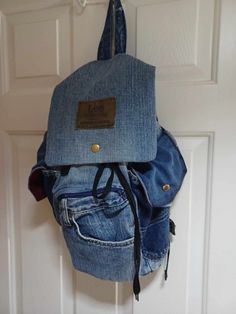 a denim backpack hanging on a door