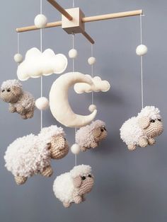 a crocheted mobile with sheep hanging from it's sides and clouds above them