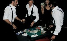 three men and two women playing cards at a table