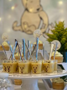 cupcakes on a cake stand with winnie the pooh face decorations and silverware