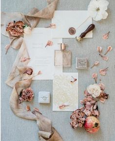 the wedding stationery is laid out on top of the table with flowers and other items