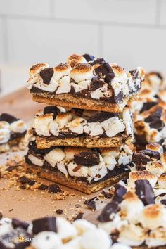 s'mores bars stacked on top of each other with chocolate chips and marshmallows