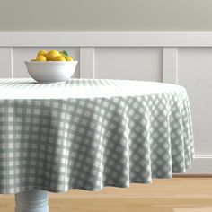 a bowl of lemons sitting on top of a green and white checkered table cloth