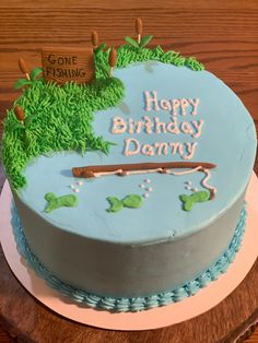 a birthday cake with the name happy birthday dany on it and fishing scene in blue frosting