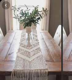 the table is set with white chairs and a plant