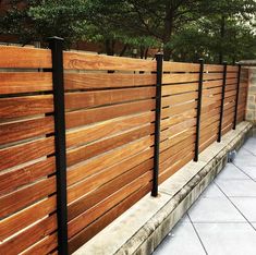 a wooden fence with black metal posts