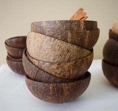 several wooden bowls stacked on top of each other with cinnamon sticks sticking out of them