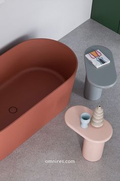 a bath tub sitting next to a table with a magazine on it's side