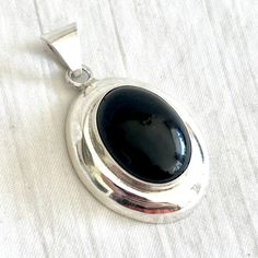 Vintage Large Onyx Pendant Mexican Sterling Silver Modern Necklace Finding Black Stone Everyday Statement Jewelry This sleek and simple pendant looks beautiful worn with almost any style. Made from a dramatic black onyx oval set in a high sterling silver setting, this pendant measures 2 1/8" (54 mm) long (including the bale), 1 1/4" (32 mm) wide and 1/2" (12 mm) hight. It is stamped with a Mexican maker's mark on the back. It weighs a substantial 18.5 grams. It is in excellent vintage condition with minimal signs of age and previous wear and is ready to wear. Is it a gift? Need to buy a card? All cards ship free with purchase. http://www.etsy.com/shop/AdobeHouseVintage?section_id=13802190 Thanks so much for looking! Silver Statement Necklace, Simple Pendant, Modern Necklace, Onyx Pendant, Silver Necklace Statement, Modern Necklaces, Statement Pendant, Vintage Mexican, Maker's Mark