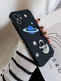 a woman holding up her phone case with cartoon stickers on the back of it