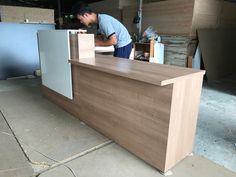 a man working on a wooden counter in a warehouse