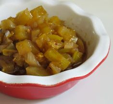 a red and white bowl filled with food on top of a table