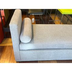 a gray couch sitting on top of a hard wood floor next to a metal table