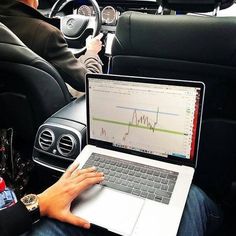 a person sitting in a car using a laptop computer