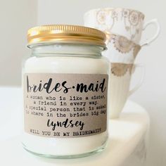 a jar with a label that says bridesmaid on it next to a cup