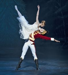 two ballerinas dressed in white and red are dancing