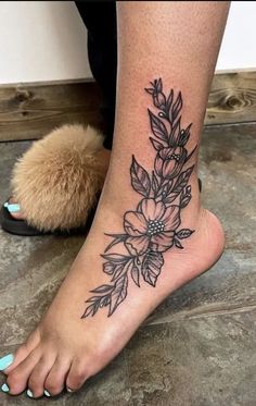 a woman's foot with a flower tattoo on her left side and the bottom part of her leg