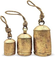 three brass bell ornaments with rope around them