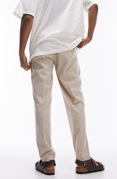 "Find TOPMAN Tapered Drawstring Pants on Editorialist. Stretchy fabric keeps you moving comfortably in these tapered drawstring pants that look smart from work to the weekend. 14\" leg opening; 11 1/2\" front rise; 16\" back rise Elastic/drawstring waist Side-seam pockets 64% polyester, 34% viscose, 2% elastane Machine wash, dry flat Imported" Tapered Leg Dress Pants With Elastic Waistband, Beige Relaxed Fit Work Pants With Tapered Leg, Relaxed Fit Tapered Bottoms For Business Casual, Business Casual Tapered Bottoms With Relaxed Fit, Business Casual Bottoms With Relaxed Tapered Fit, Tapered Bottoms With Welt Pockets, Summer Tapered Leg Chinos, Spring Tapered Business Casual Bottoms, Spring Business Casual Tapered Bottoms