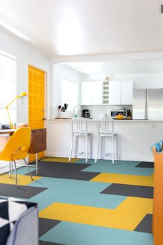 an open kitchen and living room with colorful flooring