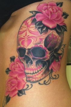 a woman's stomach with a skull and roses on it