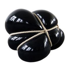 three black eggs tied with rope on white background